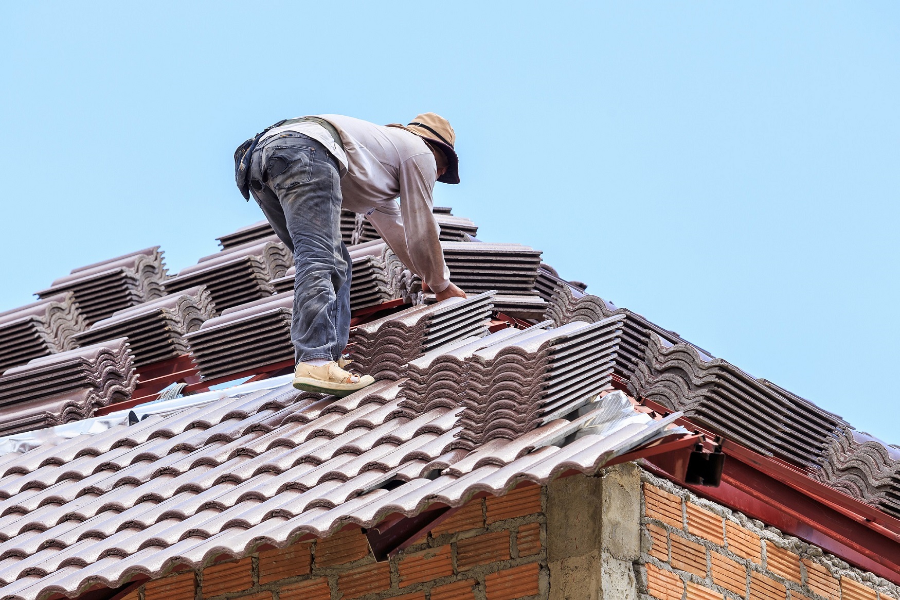 Photo Worker install roof tile for new house